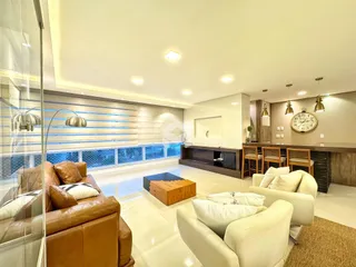 Sala de estar moderna com grandes janelas e sofás de couro.