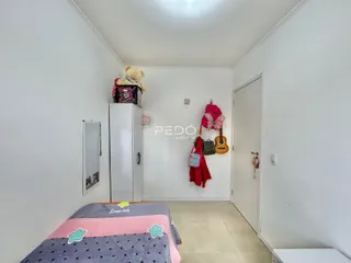 Foto de um quarto interno com cama e armário branco.