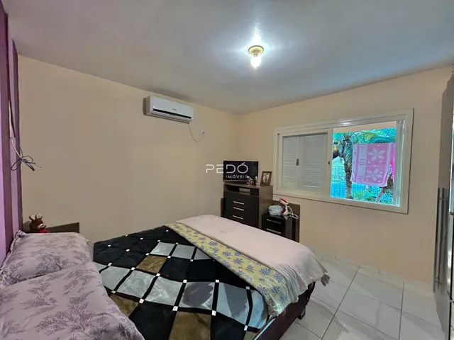 Quarto com cama e janela de vista para a vegetação.