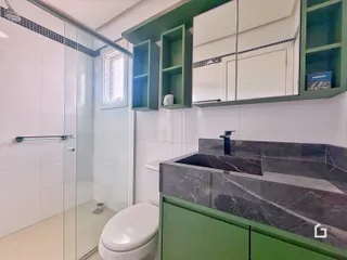 Foto de um banheiro com box de vidro e revestimento branco.
