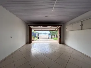 Hall de entrada com piso de cerâmica e paredes brancas.