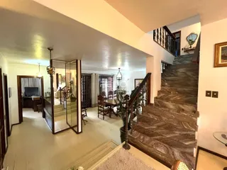 Vista de um corredor com escadaria e acesso a outras áreas da residência.
