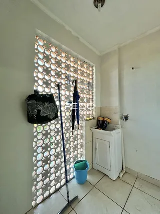Banheiro com revestimento cerâmico claro na parede.