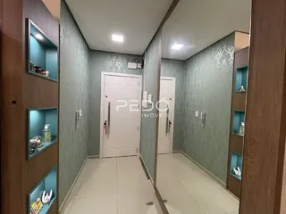 Corredor interno de uma residência com paredes verdes e portas brancas.
