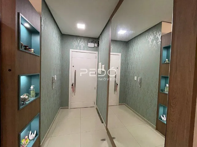 Corredor interno de uma residência com paredes verdes e portas brancas.