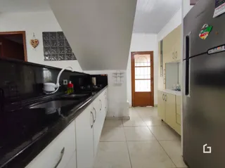 Cozinha com armários e bancadas escuras.