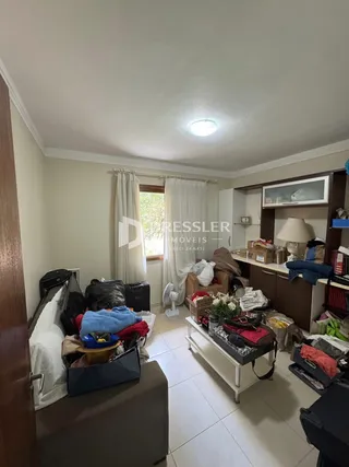Foto de uma sala de estar interior com paredes claras e piso de cerâmica.