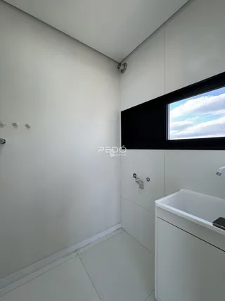 Foto de um ambiente interno com paredes brancas e piso claro.
