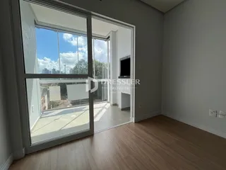Vista interna de um ambiente com grandes portas de vidro que dão acesso a uma área externa.