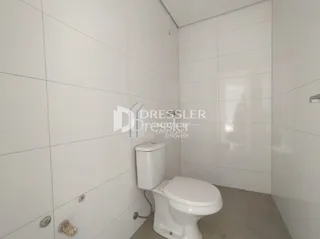 Foto de um banheiro com paredes brancas e revestimento cerâmico.
