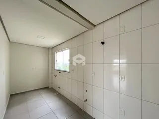 Corredor interno com piso de cerâmica e paredes brancas.