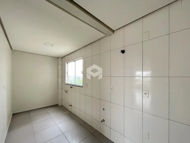 Corredor interno com piso de cerâmica e paredes brancas.