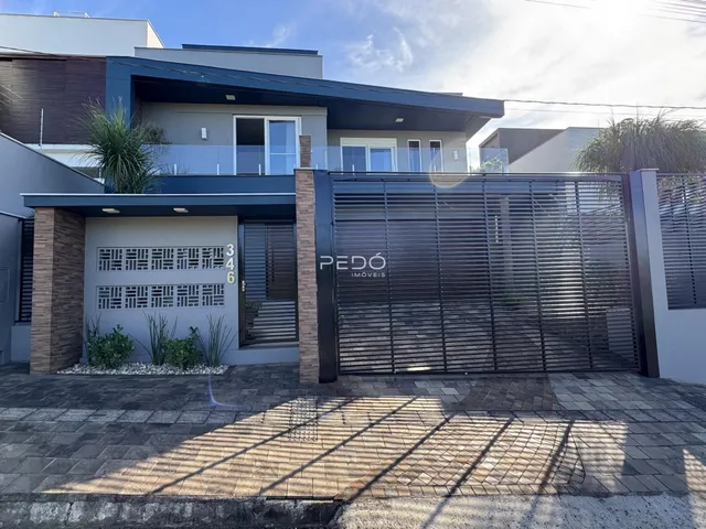 Fachada de uma residência moderna em Lajeado, Brasil, com portão de ferro.