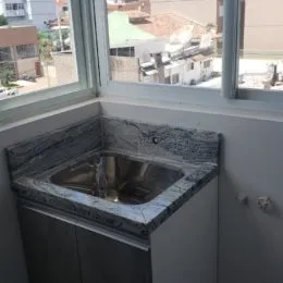 Vista de uma pia de aço inoxidável em uma bancada da cozinha.