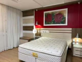 Foto de um quarto com cama grande e painéis de madeira na parede.