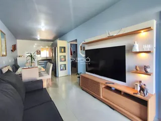 Sala de estar com sofá e mesa de jantar em um apartamento.