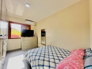 Quarto com cama e janela com vista para a paisagem.