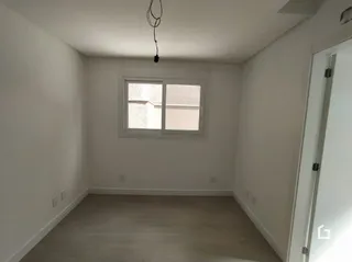 Vista interna de um cômodo com paredes brancas e piso claro.