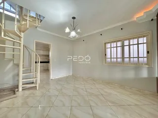 Ambiente interno com piso de cerâmica e escadaria em uma sala de estar.