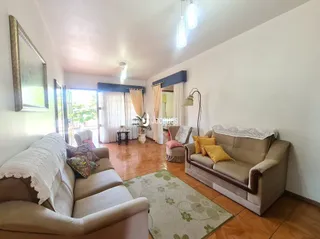 Sala de estar com piso de madeira e sofá claro.
