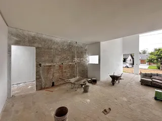 Um espaço interior com paredes de concreto aparente e piso de concreto.