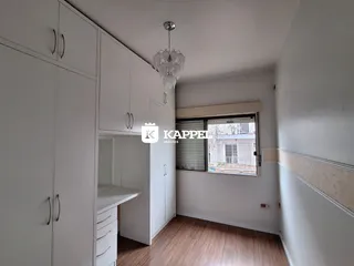 Ambiente interno com armários brancos e piso de madeira clara.