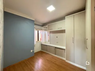 Quarto com armários embutidos e piso de madeira clara.