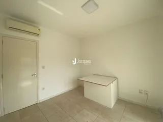 Interior de uma sala com piso de cerâmica e parede branca.