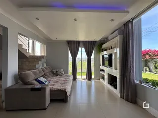 Sala de estar com vista para o exterior e lareira moderna.