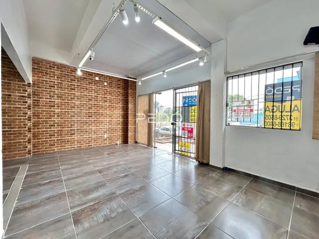 Ambiente interno com paredes de tijolo aparente e piso de concreto.