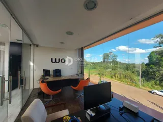 Vista interna de um escritório com grande janela para a paisagem rural.