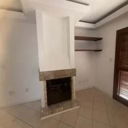 Detalhe de uma lareira com revestimento de pedra em um ambiente interno.