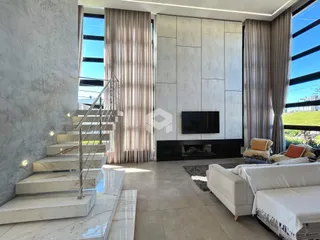 Sala de estar moderna com lareira e escadaria em um imóvel no Brasil.