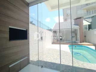 Vista da sala de estar com acesso a uma área externa e piscina.