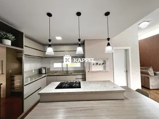 Uma cozinha moderna com ilha central e bancada de granito.