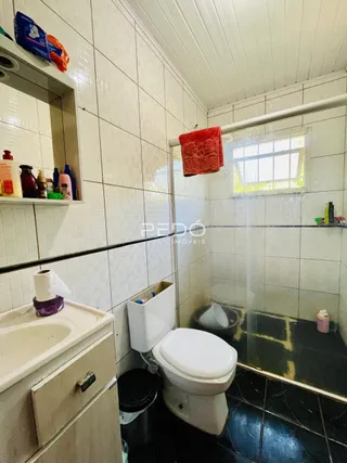 Foto de um banheiro com azulejos brancos e box de vidro.
