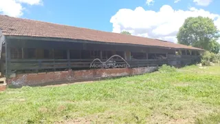 Foto da fachada de uma construção rústica com telhado de telhas em um ambiente gramado.