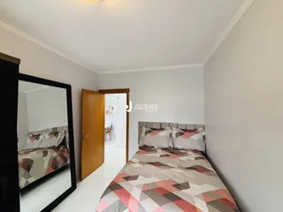 Quarto com cama e espelho em um imóvel.