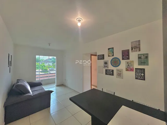 Sala de estar com sofá e piso de cerâmica em um imóvel no Brasil.