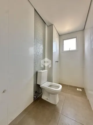 Um banheiro com revestimento cerâmico e piso claro.