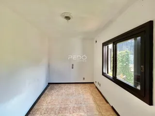 Interior de um corredor com piso de cerâmica e paredes brancas.