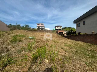 Vista externa de uma propriedade com vegetação seca em primeiro plano.