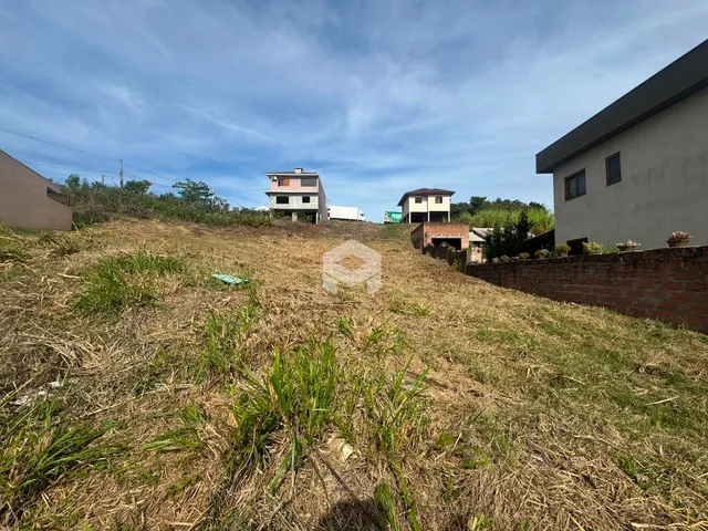 Vista externa de uma propriedade com vegetação seca em primeiro plano.
