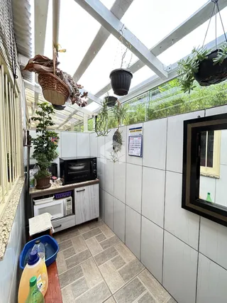 Interior de uma cozinha com piso de cerâmica e estrutura de vigas brancas.