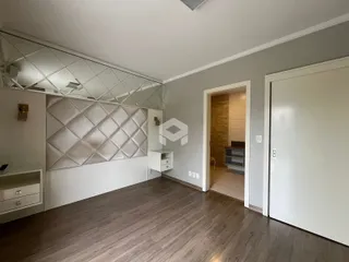 Uma sala de estar com piso de madeira clara e paredes cinzas.