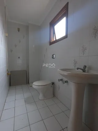 Foto de um banheiro com piso de cerâmica e azulejos brancos.