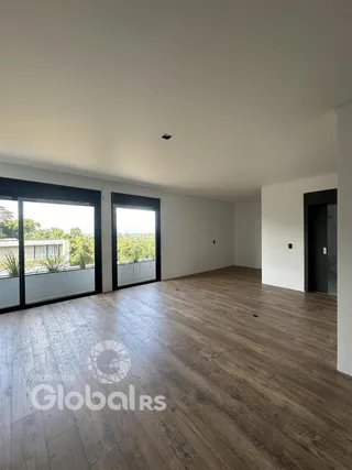 Sala de estar com piso de madeira e grandes janelas.
