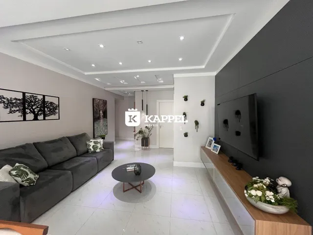 Sala de estar moderna com sofá cinza e decoração minimalista.