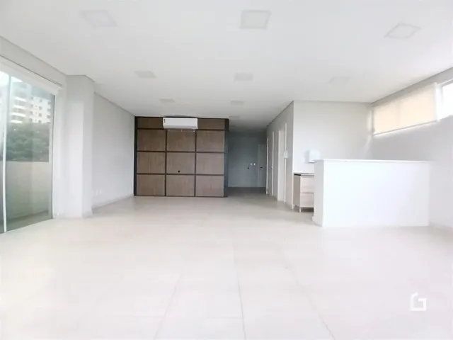 Um corredor amplo com piso claro e paredes brancas é visível na propriedade.