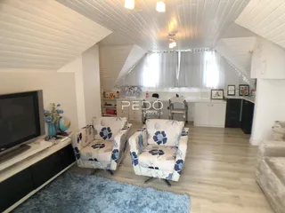 Sala de estar com teto abobadado e móveis de decoração.